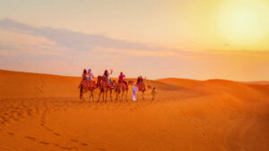 camel caravan with tourists on desert safari adventure1